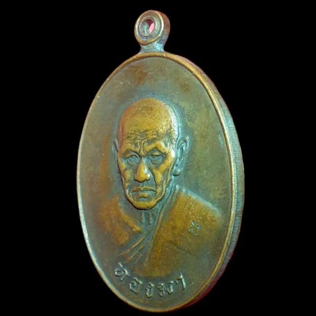 Luang Phor Thongma amulet, oval, Copper, Wat Sawang Tha Si, Roi Et, BE 2518 — front, angled left
