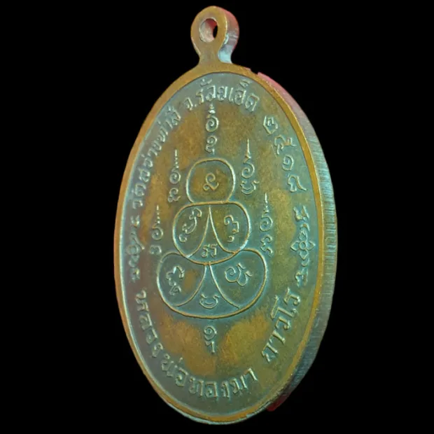 Luang Phor Thongma amulet, oval, Copper, Wat Sawang Tha Si, Roi Et, BE 2518 — back, angled left